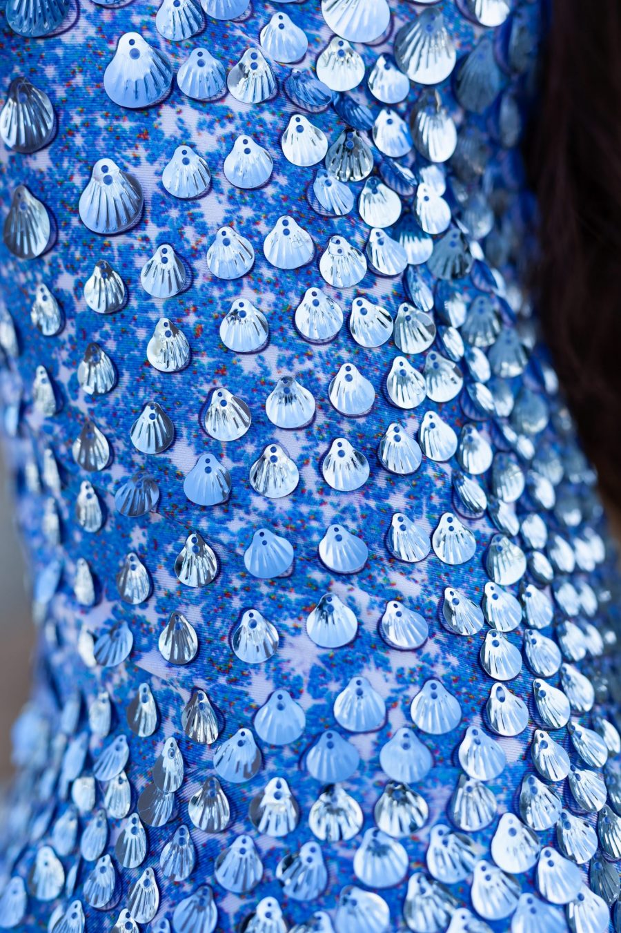 A shimmering aqua blue festival dress covered in shell-shaped sequins, designed with a mermaid-inspired silhouette and built-in bodysuit for comfort. The dress catches the light with every movement, creating a sea breeze effect, perfect for festivals or evening events.